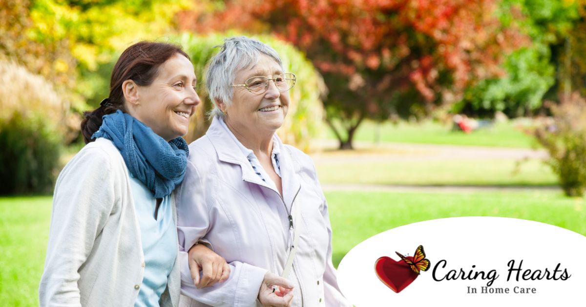 A recently retired woman enjoys her caregiving job as she walks with a senior client outside.