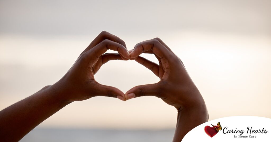 2 hands making a heart represent self-care, a vital concept to appreciate as a caregiver.