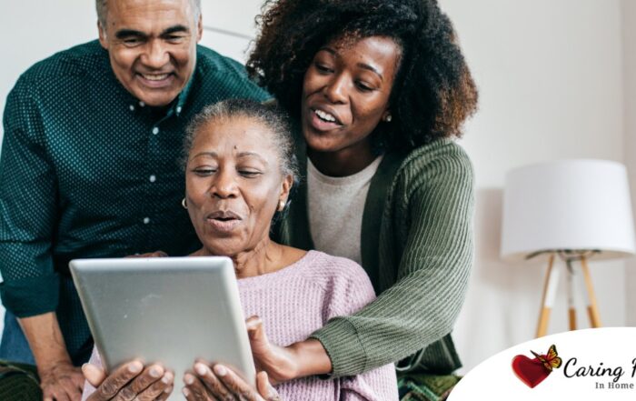 A daughter looks at a tablet with her older parents, representing technology and how ti can help with aging in place.