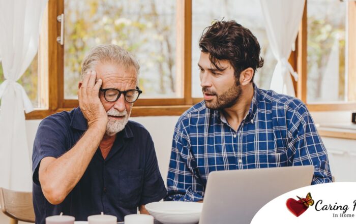 A man looks at a computer with his father who is confused, representing one of the early signs of dementia.