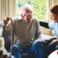 A woman has a good time with her older clients, representing the kind of personal skills needed to be a good caregiver.