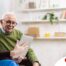 Home caregiver assisting senior man to use telehealth and senior care